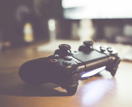 Controle de videogame preto sobre uma mesa, simbolizando jogos e entretenimento digital